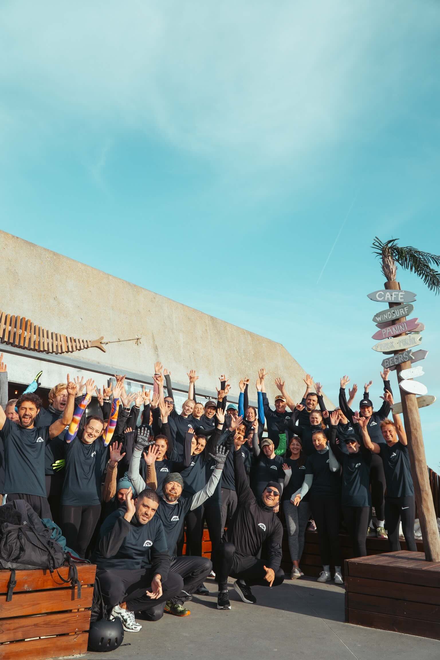 Et hold glade surfere med armene i vejret på Copenhagen Surf School