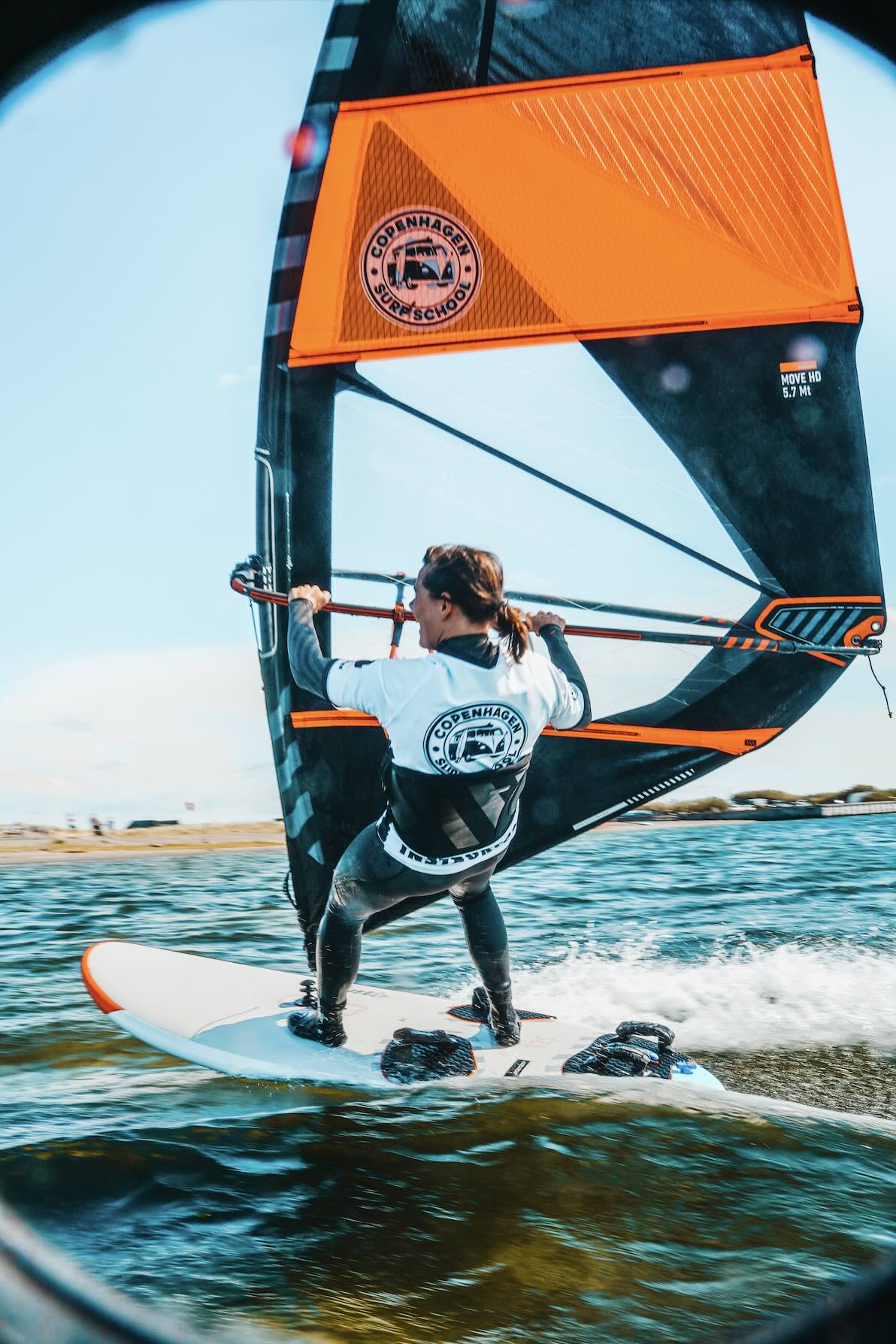 En pige windsurfer i fuld fart henover vandet i København