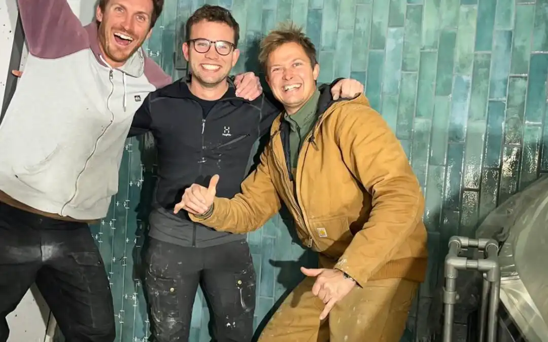 Three guys who are happy because they have finished building a café wall at Amager Strandpark Café on the pier.