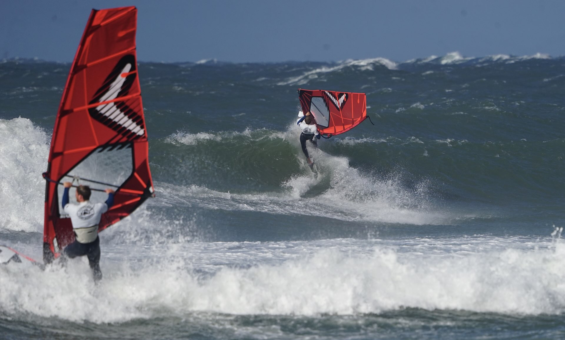 Windsurfing i Danmark på en strand på nordsjælland hvor to windsurfere forsøger at trænge gennem brændingen